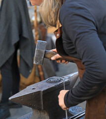 mujer herrera forjadora en el yunque trabajando con el martillo manos forja fuego 4M0A8494-as25