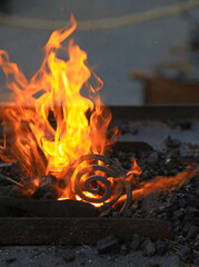 fuego espiral de hierro al rojo vivo en la fragua forja de carbón forjador herrero  4M0A8500-as25