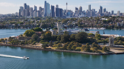 Naklejka premium Aerial drone view of Cockatoo Island on Parramatta River and Sydney Harbour, in Sydney, NSW Australia in October 2025 with Sydney City lens blur in the background 