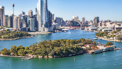 Fototapeta premium Aerial drone view of Goat Island on Parramatta River and Sydney Harbour, in Sydney, NSW Australia in October 2025 with Sydney City lens blur in the background 