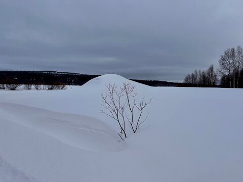 A snowy winter landscape on a frozen lake in Finnish Lapland.