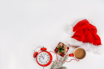 Christmas and New Year holiday composition. Flat lay with blank copy space. An alarm clock with decorations on an isolated background. Top view festive concept.