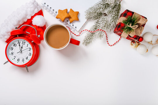 Christmas and New Year holiday composition. Flat lay with blank copy space. An alarm clock with decorations on an isolated background. Top view festive concept.