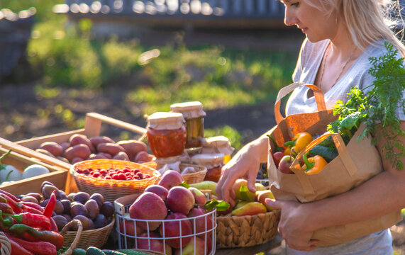 A woman buys fruits and vegetables at a farmers market. Selective focus.