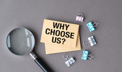 Concept word Why choose us on beautiful yellow paper White table with brown background. Business...