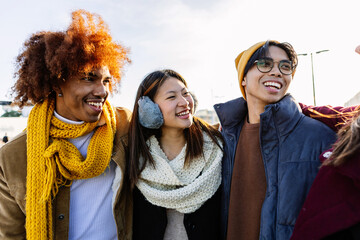 Diverse group of gen z happy friends having fun together on winter vacation. Multicultural teenage...