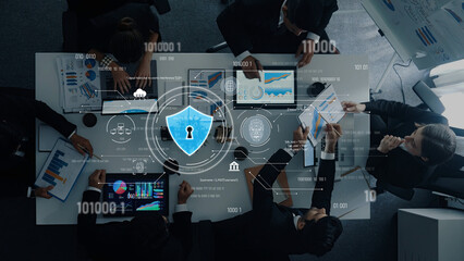 A top view of a professional business meeting focusing on cybersecurity analytics with digital lock icon overlay. Teams collaborate on data-driven strategies in a modern office. Trope