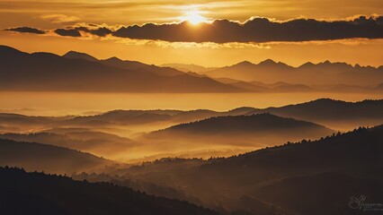 Golden sunset over misty mountain range with layered hills and valleys