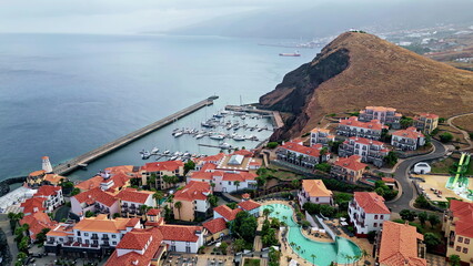 Town built coast slopes washed by Atlantic Ocean aerial view. Residential houses