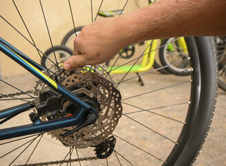 Mechanic's hand using a tool to tighten bolts on a bicycle disc brake