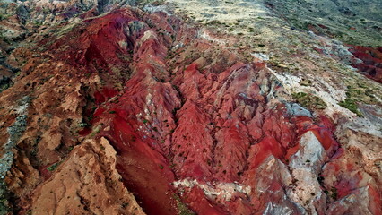 Drone red rock slopes with erosion lines. Picturesque stone formations scattered