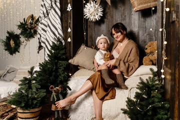 A mother and child in a prince costume sit in a closet on mattresses like in a fairy tale.