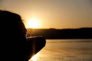 Person admiring the sunrise on the lake