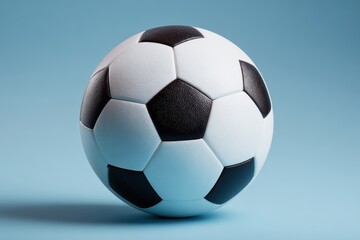 Naklejka premium Classic soccer ball on soft blue background highlighting textured surface and classic black and white panel design, perfect for sports enthusiasts and football-themed projects