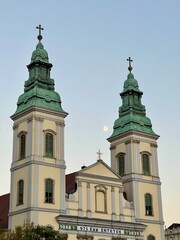 Budapest inner-city parish church towers with moon
