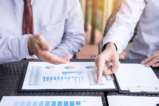 Business people discuss together about there work by graph document and setting in outdoor for planning financial strategy.