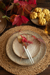 Festive Autumn Table Setting with Ceramic Plates, Pumpkins, Cake and Rustic Decor