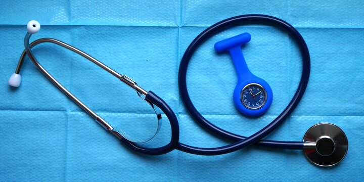 St&eacute;thoscope et montre trotteuse sur fond de champ st&eacute;rile, outils infirmiers en milieu hospitalier ou en consultation