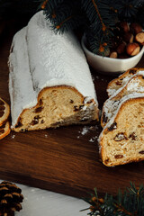 Christmas stollen on a wooden board with green branches of a Christmas tree. Christmas background, Christmas desserts