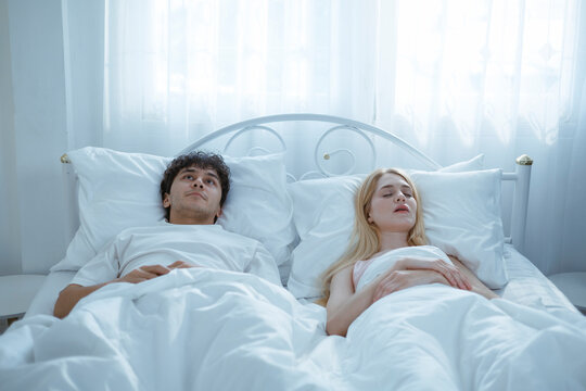 A young man is trying to stop his wife from snoring because she snores very loudly.