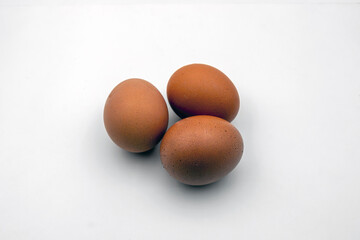 Top-down view of three brown eggs grouped together, isolated for use in food design, recipe illustration, or packaging mockups.