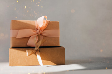Greeting background. Brown and pink gift boxes on a gray background with copy space. Front view