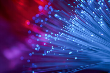 Vibrant glowing fiber optic strands emitting blue and red light with a bokeh effect illustrating high-speed data transmission and modern technology concepts