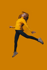 Energetic woman in yellow attire soaring with lively movement