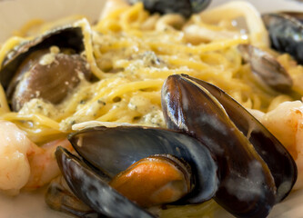 Pasta with seafood and sauce. Close-up of spaghetti with clams, shrimp, and seafood cocktail.