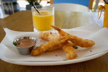 Close-up of battered shrimp with sauce on a light bowl. Seafood concept.