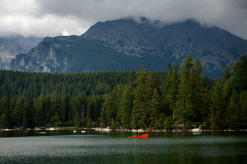Serene Lake with Red Boat and Mountain View