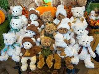 An autumn display featuring a group of plush teddy bears dressed in white fleece and brown hooded...