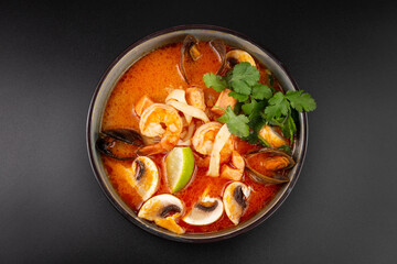 Spicy Thai Tom Yam soup with coconut milk, tiger prawns, mussels,squid,trout, and mushrooms. rice and lime