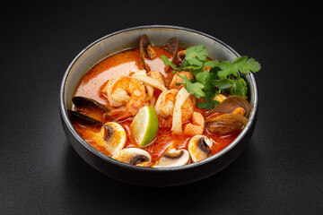 Spicy Thai Tom Yam soup with coconut milk, tiger prawns, mussels,squid,trout, and mushrooms. rice and lime