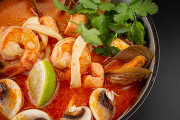 Spicy Thai Tom Yam soup with coconut milk, tiger prawns, mussels,squid,trout, and mushrooms. rice and lime