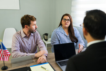 Serious couple receiving immigration legal advice from attorney