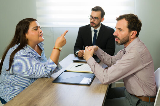 Angry couple arguing during divorce mediation meeting with lawyer