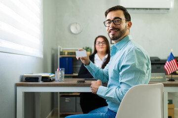 Happy man showing new visa at lawyer office
