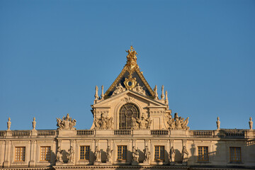 Obraz premium Palace of Versailles with sculptural pediment and classical columns in a historical and artistic setting