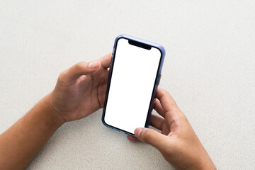 Hand holding smartphone with a blank screen on table, with blank space screen for advertising text
