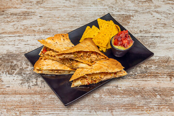Squash blossom quesadillas with melted Oaxaca cheese, chopped onion, and fresh epazote on freshly made blue corn tortillas