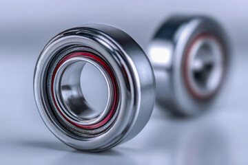 Shiny metallic ball bearings with red sealing rings placed on smooth surface showcasing engineering precision and industrial component design