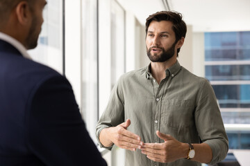 Young Caucasian business man in casual talking to male expert
