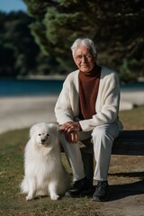 Elderly caucasian male with white dog enjoying a peaceful day at the park