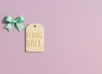 Flash sale tag and mint bow on pastel purple background