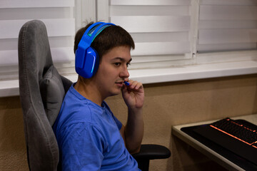 Gamer equipped with vibrant blue headphones, interacting through microphone. Moment captures essence of modern gaming culture, where communication plays key role in teamwork and strategy