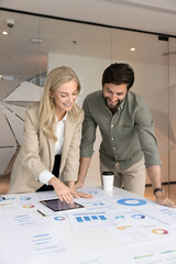 Two positive marketing agency analysts discussing paper diagrams