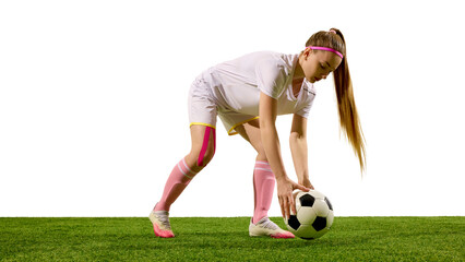 Female football player bending forward holding ball before practice on green field. Concept of training and coaching, health recovery, sportswear advertising, and digital branding.
