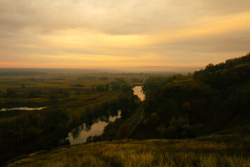 Obraz premium Scenic view of a winding river surrounded by autumn fields