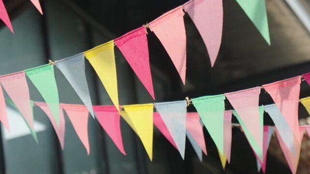 Vibrant yet gentle colored party flags waving softly in the breeze, setting the scene for a joyful festival or garden gathering